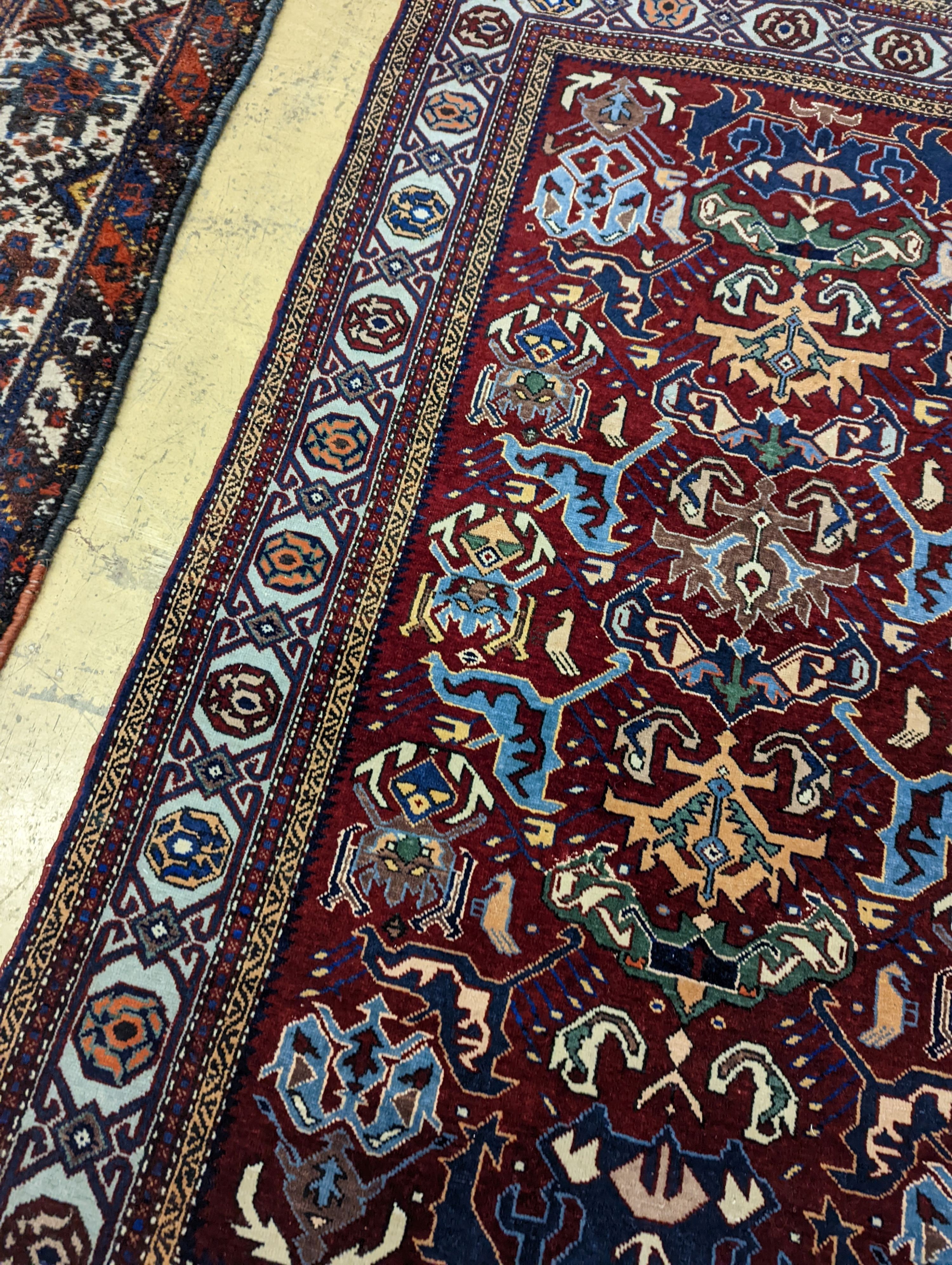 A Caucasian design burgundy ground rug, 153 x 100cm